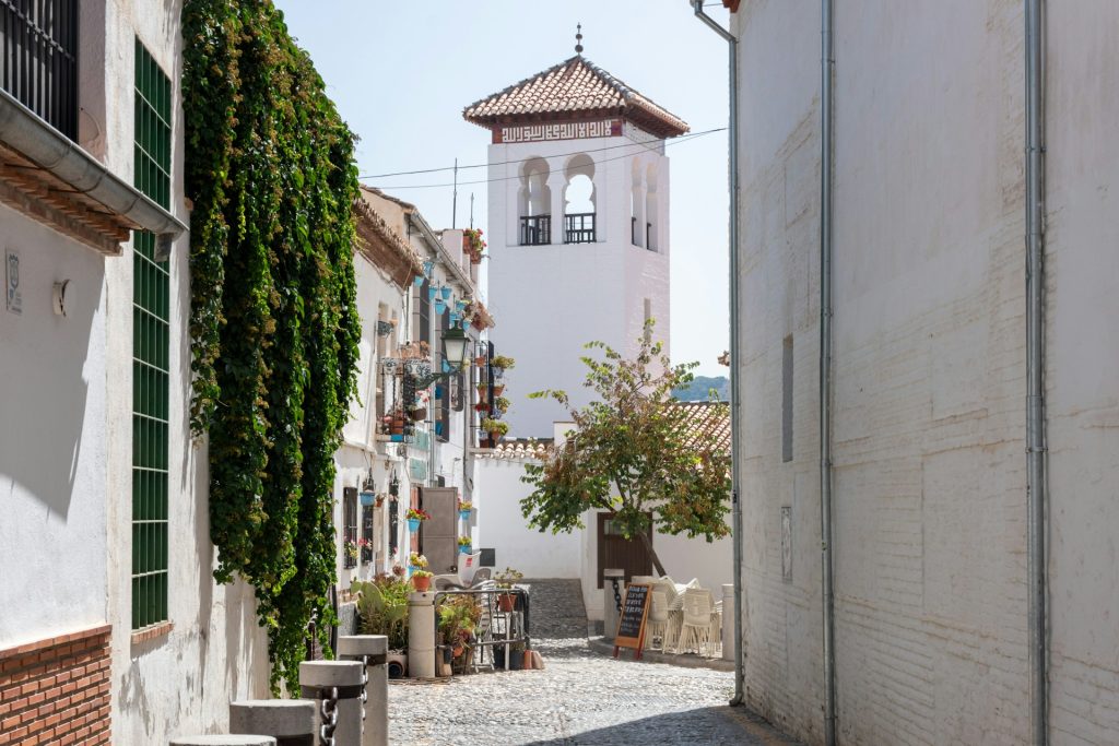 Street in Granada with traditional historic buildings and whitewashed facades