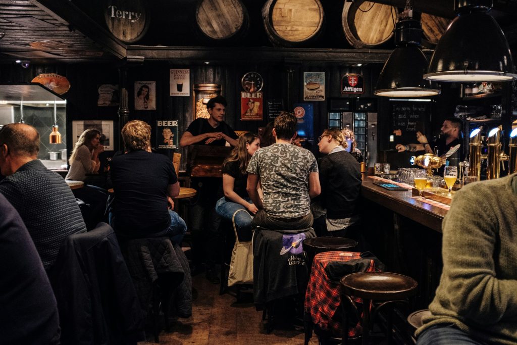 People ordering drinks at a busy pub