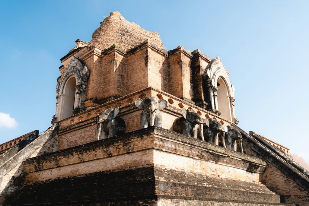 Wat Chedi Luang in Chiang Mai, Thailand, featuring the ancient brick chedi with elephant sculptures around the base.
