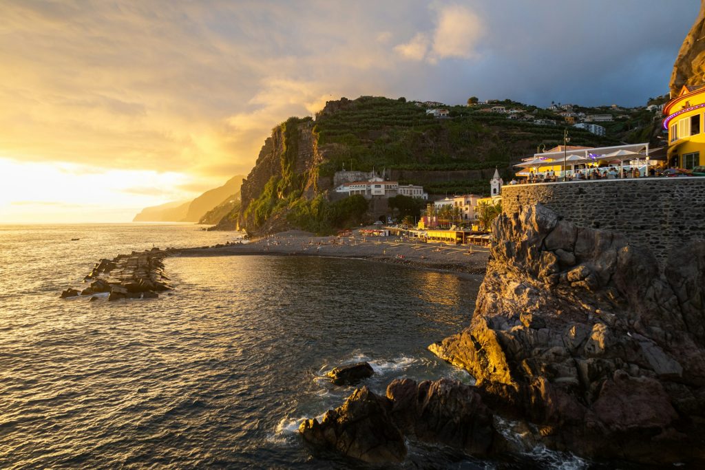 Sunset over the ocean and a small coastal town in Madeira, capturing the island’s atmosphere and charm.