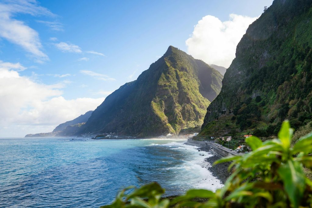 Panoramic Madeira landscape with green mountains and the Atlantic Ocean, inspiring local souvenirs.