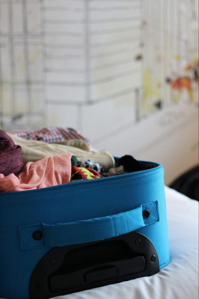 Open suitcase packed with travel clothes