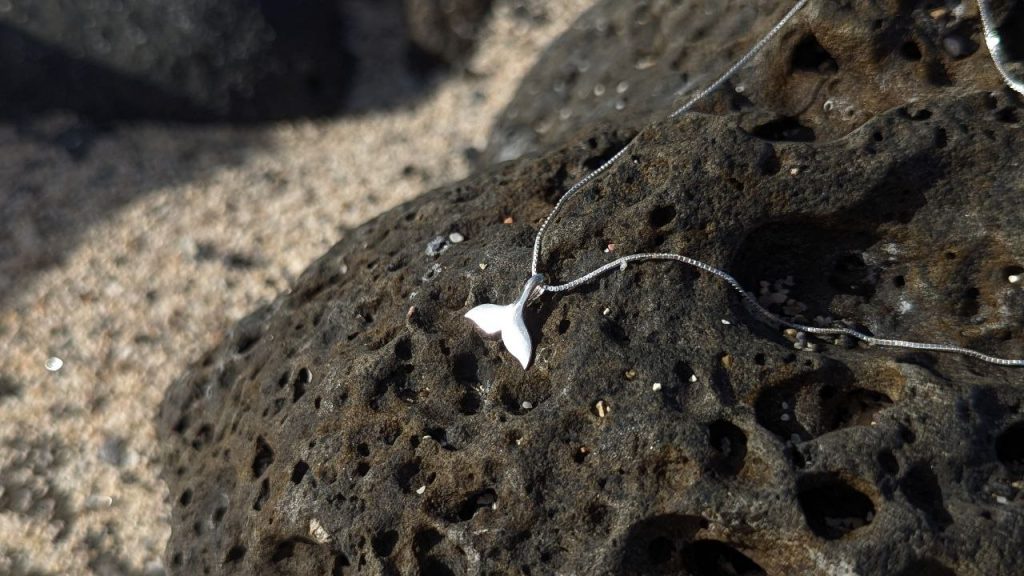 Silver jewelry displayed on volcanic rock in Madeira, a unique island-inspired souvenir.